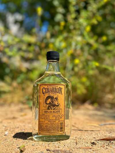 A 375 ml flask of Cimarron Blanco Tequila with a brown label and black cap.