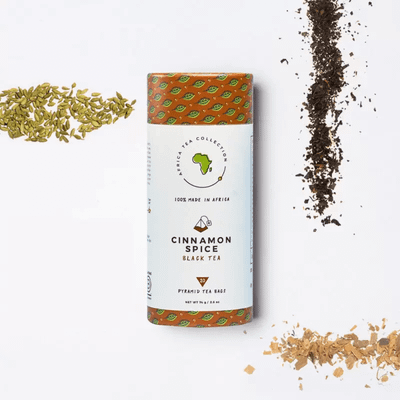 A cylindrical package of Kazi Yetu Cinnamon Spice Black Tea featuring a white and green design with orange accents.